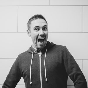 Man with short brown hair and surprised expresssion on this face.