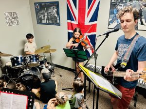 Children aged eight to ten playing in a Rock Band.
