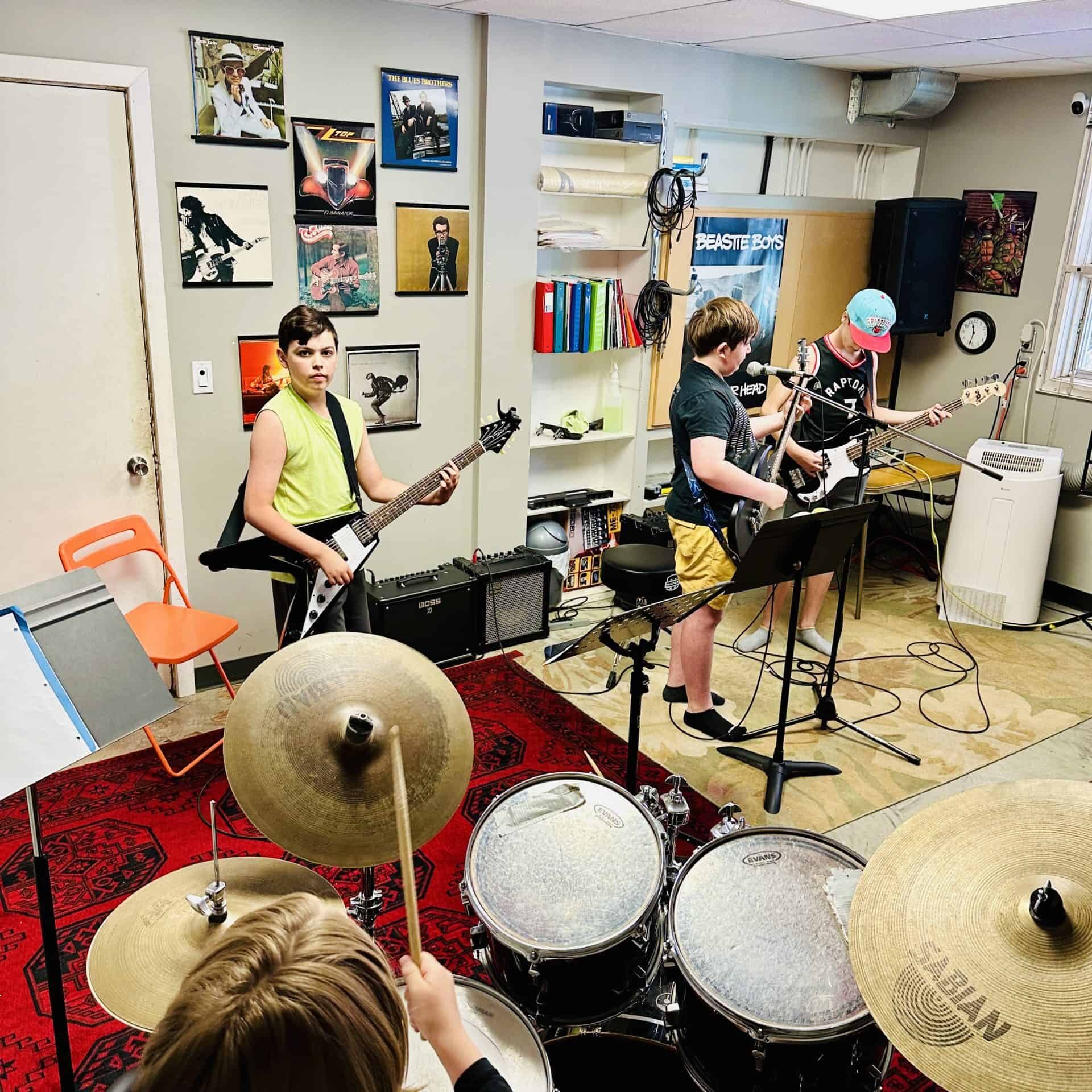 Summer Rock Camp in Edmonton Four students between the ages of 10-12 play in a rock band together.